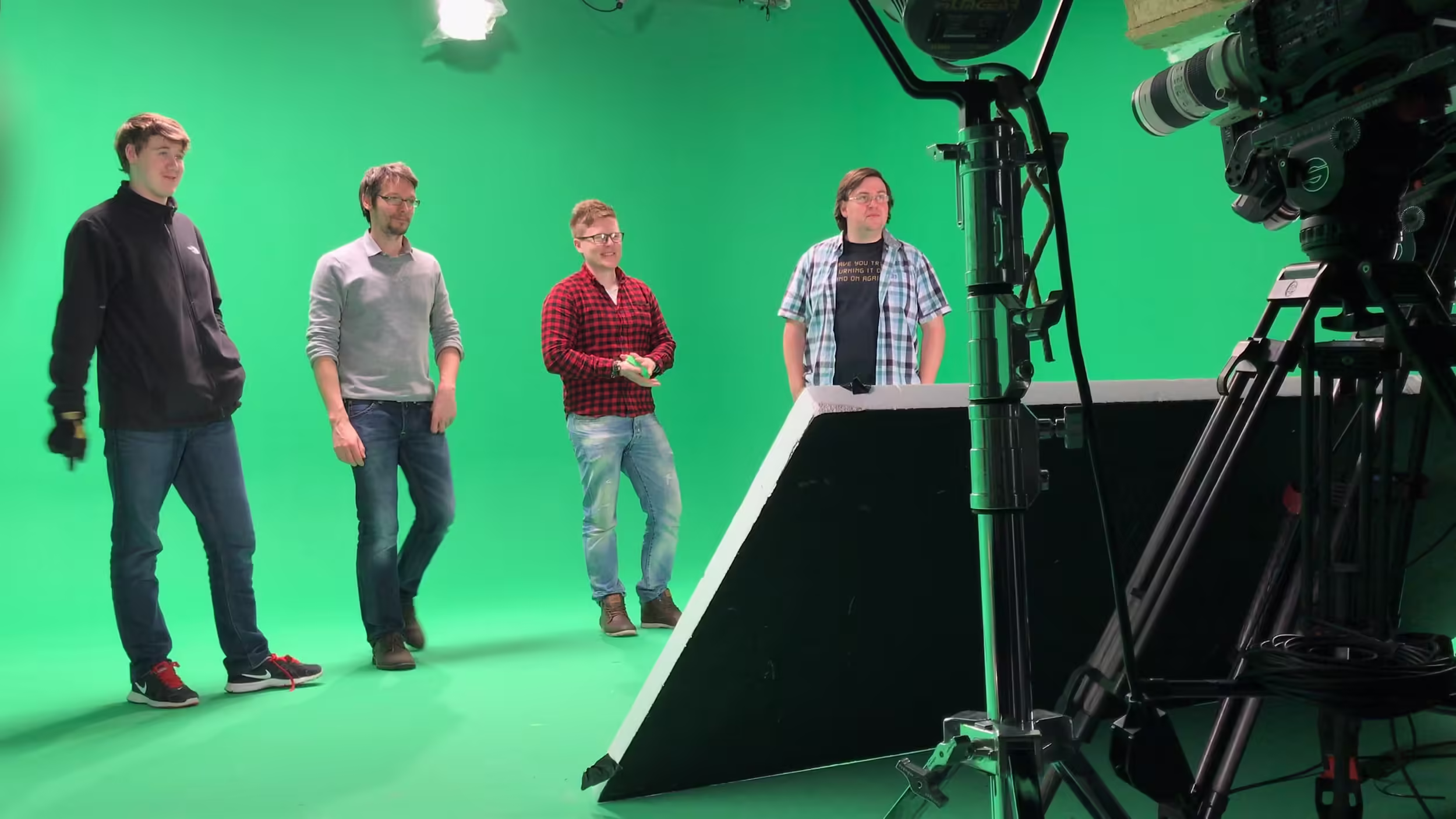Andy, Craig and James standing in on a green screen during lunch having a go on autocue.