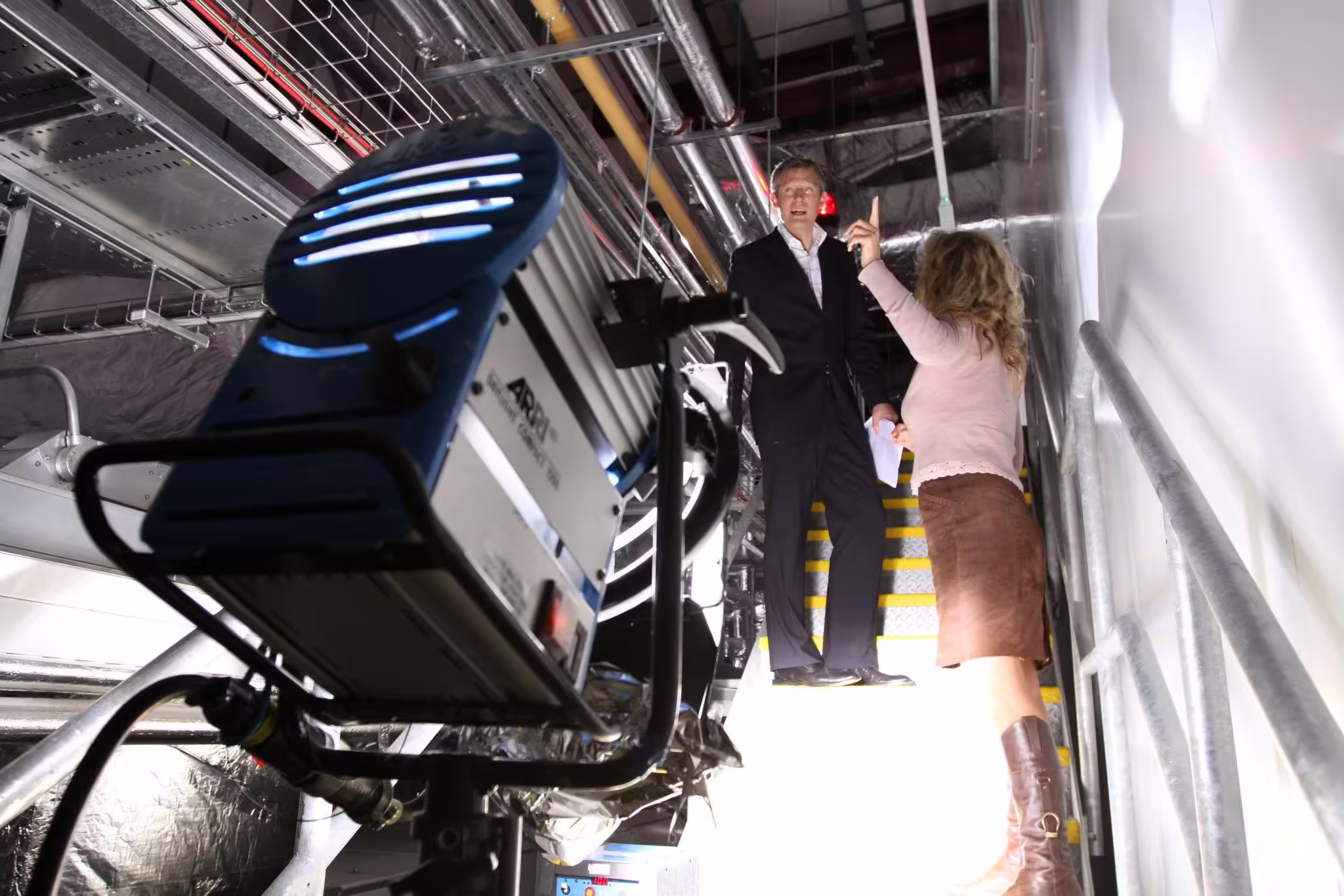 A behind the scenes photo during filming of Points of View with presenter Jeremy Vine being briefed by the director and a light in the foreground in the archives of BBC Television Centre