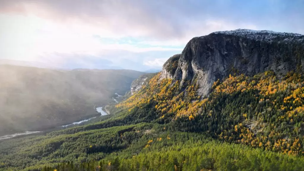 Sun shining through the clouds onto a cliff face, Photographed by Craig Hale