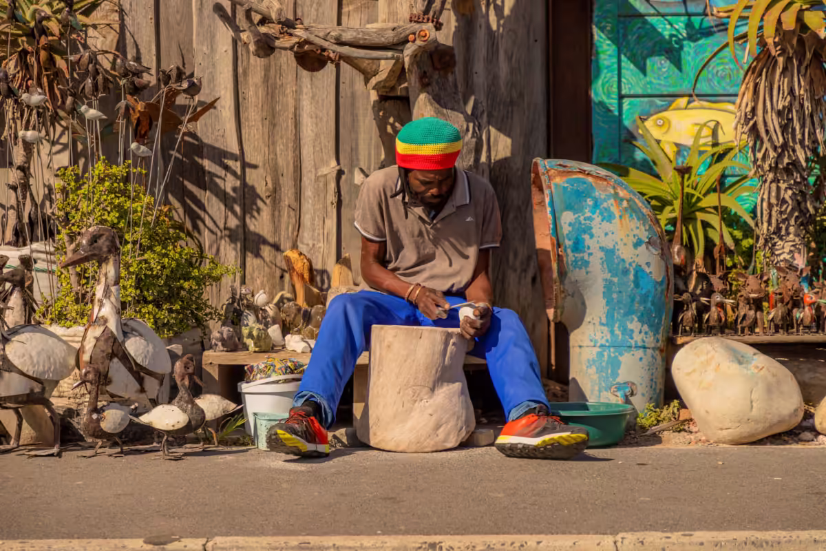 A man carving some wood in South Africa photographed by James Bailey