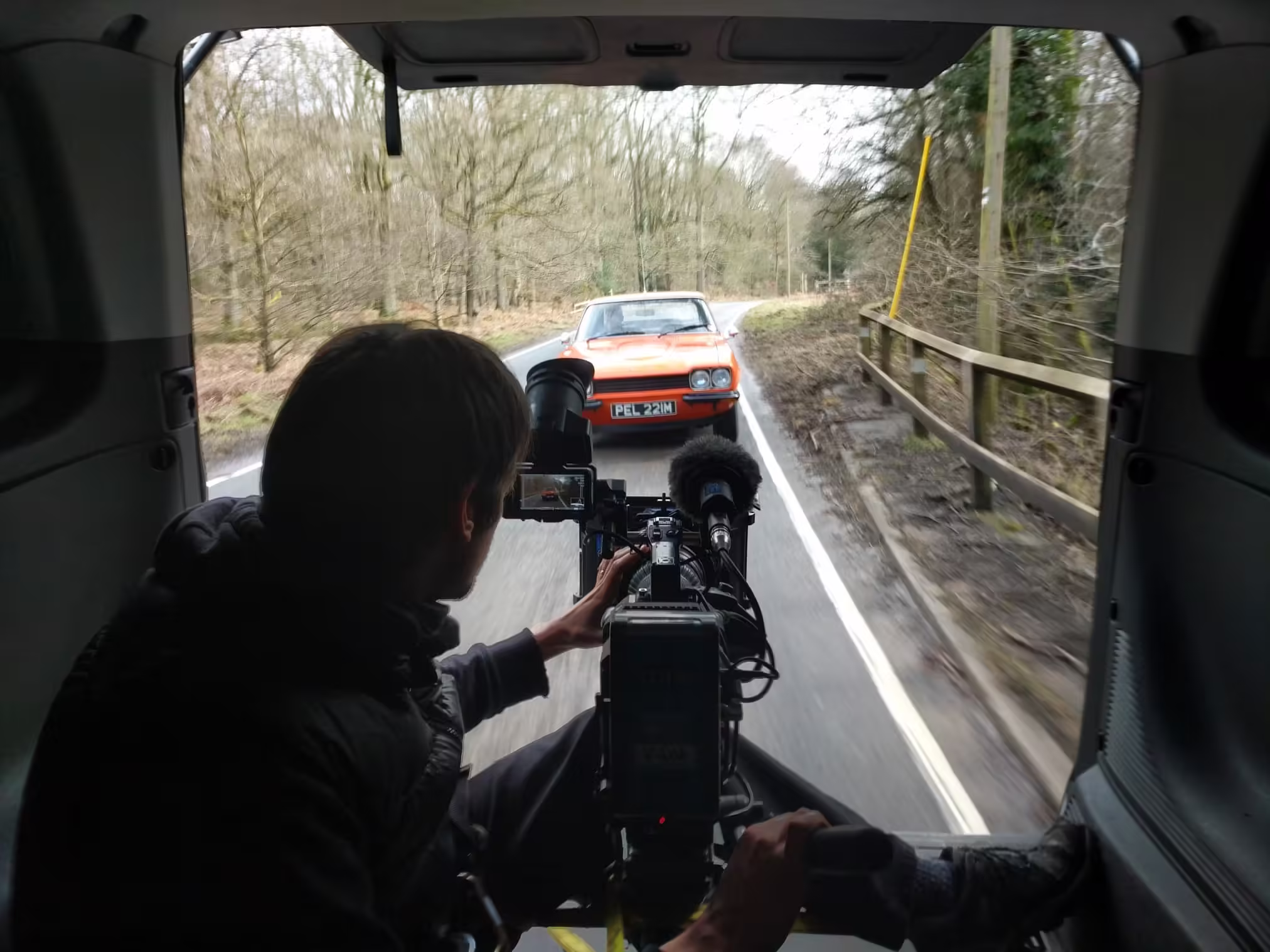 Andrew Davis filming a tracking shot of a Ford Capri for Car SOS with Sony FX9 and Canon CN7 from the rear of a moving vehicle